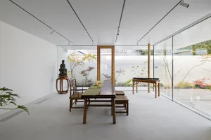 A minimalist interior design featuring a white concrete floor and wooden furniture.