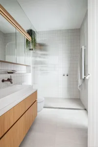 Modern bathroom with white textured tiles and wooden vanity