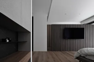 A modern bedroom featuring dark wood paneling