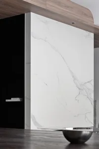 Modern kitchen with white marble countertop and black shelves.