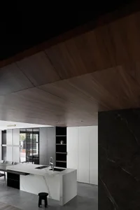 Modern kitchen with minimalist design, featuring a marble countertop and wooden cabinets.