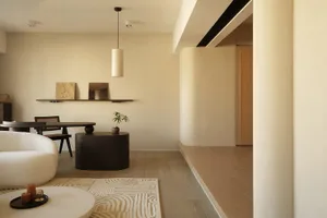 A minimalist living room with concrete furniture and wooden flooring.
