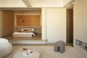 Minimalist residential interior with wooden and concrete elements, fabric accents, and a modern design