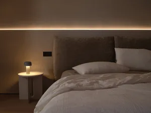 Minimalist bedroom with fabric headboard and linen bedding.