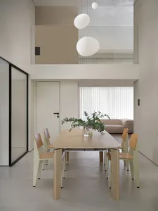 簡約餐廳內擺放一張木質長方形餐桌，四把現代風格餐椅環繞其旁，桌上擺放一盆裝飾性綠植