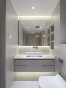 A modern bathroom featuring a sleek, minimalist design with concrete and glass elements.