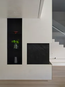Modern interior design featuring a concrete shelving unit with minimalist black shelves and decorative elements.