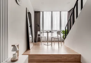 A modern, minimalist interior with white furniture, wooden flooring, and glass windows.
