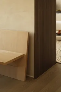 A minimalist wooden bench in a modern interior space.
