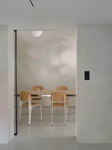 Modern minimalist dining room with a concrete and wooden table and chairs