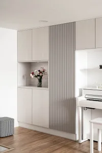 Modern minimalist living room with wooden cabinets and a white piano.