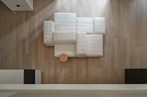 Modern minimalist sofa upholstered in white fabric, featuring a contemporary design.