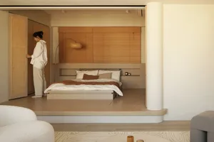 A minimalist bedroom with a wood platform bed, white bedding, and a wooden slat partition.