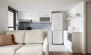 A minimalist kitchen with white cabinets and a modern design.