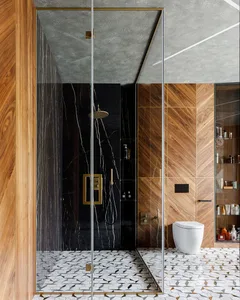 A modern bathroom featuring marble walls and floor, wooden accents, and a glass shower enclosure.