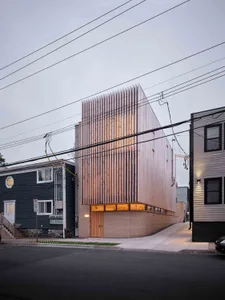 A modern residential building exterior featuring a combination of wood and brick materials.