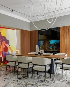 Modern dining room with a wooden table and chairs, marble floor, and abstract wall art.