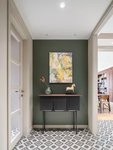A modern entryway featuring a patterned tile floor and minimalist design elements.