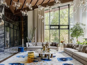 Modern living room with marble flooring, sofas, and decorative elements.