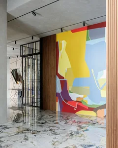 A modern lobby with a colorful abstract mural on a wall.