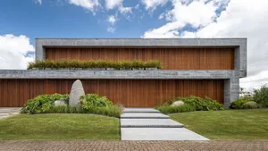 A modern residential building with a concrete exterior and greenery on the roof.