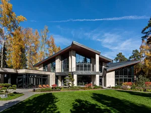 A modern residential exterior featuring stone and glass materials.