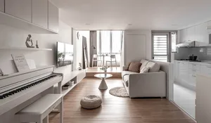 A modern minimalist living room featuring white furniture and wooden accents.