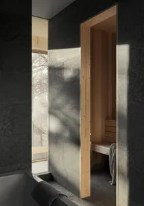 Modern bathroom with gray marble walls and a sauna in the background.