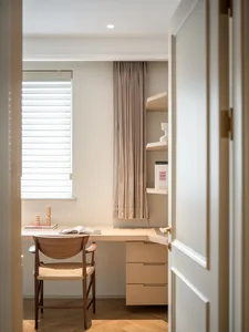 A modern home office featuring wooden furniture, a window with blinds, and a bookshelf.