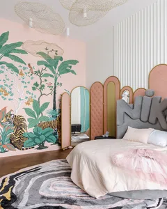 A modern bedroom featuring a tropical wall mural with palm trees and a tiger. The room has a grey upholstered bed with a pink
