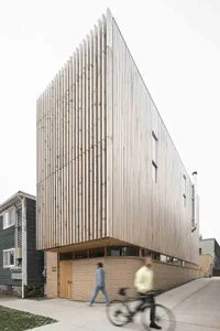 A modern residential building with a wooden facade and slatted wooden panels.