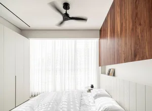 A modern bedroom featuring white bedding on a wood headboard, with a large window covered by sheer curtains.