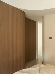 A modern bedroom featuring wooden cabinets.