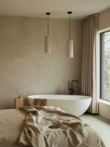 A minimalist bedroom featuring a cotton-blend blanket and curtains.