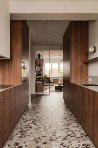 Modern kitchen featuring terrazzo flooring and wooden cabinetry.