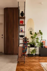 Modern living room with wooden shelves, a concrete floor, and potted plants