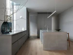Modern minimalist kitchen with concrete countertops and floor.