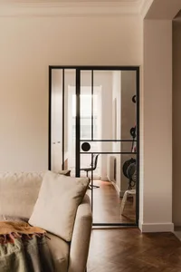 A minimalist living space featuring a glass sliding door and a wooden floor.