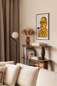 A modern living room featuring a wooden bookshelf with books, a floor lamp, and dried palm leaves in a vase.