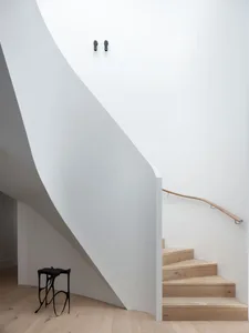 Modern interior design featuring a wooden staircase on white walls, minimalistic and contemporary