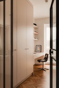 Contemporary minimalist home office featuring a sleek white desk and modern white cabinets.