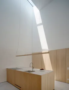 Modern kitchen with wooden cabinets and a skylight.