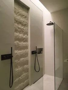 Modern minimalist bathroom featuring concrete walls and a walk-in shower.