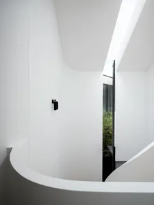 A modern interior space with white walls, concrete floor, and black lights