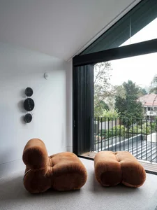 Minimalist living room featuring brown velvet furniture and large glass window.