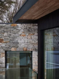 A modern building with a flat roof and stone walls.