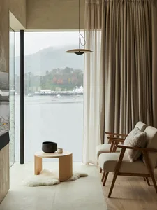 A modern minimalist residential interior featuring concrete, wood, and glass materials.