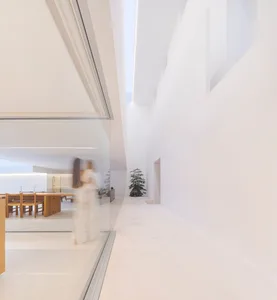 Modern minimalist interior with white marble floors and walls, featuring clean lines and natural light.