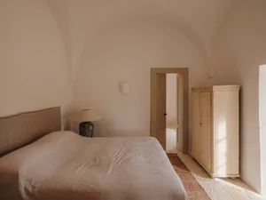 Minimalist bedroom with a bed, lamp, and white wardrobe