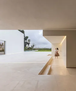Modern minimalist residential interior with concrete floor and walls and glass walls and doors.